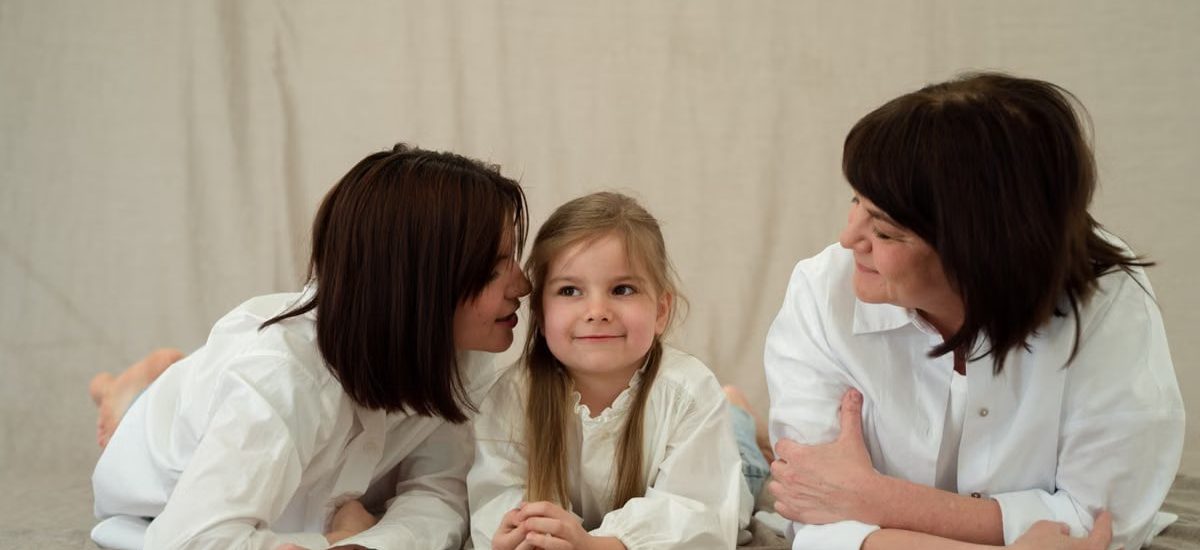 Three generations of women smiling together, symbolizing familial love and connection.