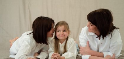 Three generations of women smiling together, symbolizing familial love and connection.
